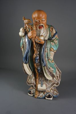 statue d'un homme barbu vêtu d'une robe bleue et tenant un oiseau