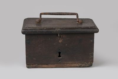 une vieille boîte en métal munie d'une poignée, sur fond blanc