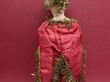 a small doll that is on top of a wooden stick