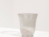 un vase en verre posé sur un socle blanc dans une pièce