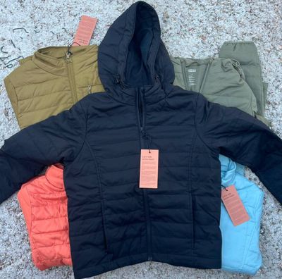 three jackets and pants laid out on the ground with a price tag on them