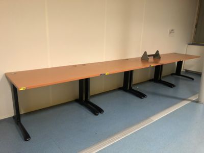 trois tables dans une pièce au sol bleu et aux murs blancs