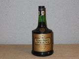 une bouteille d'alcool posée sur une table, avec un mur en arrière-plan