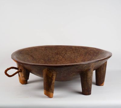un vieux bol en bois posé sur un socle en bois