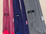 several ties are lined up on a table with a name tag