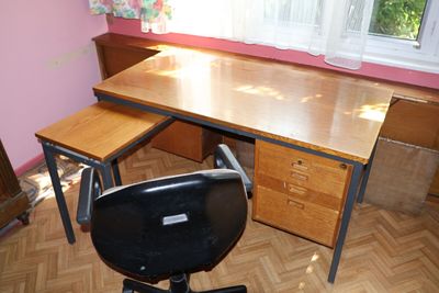 un bureau avec une chaise devant une fenêtre