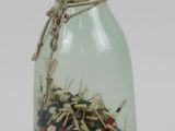 a glass bottle filled with a lot of small objects