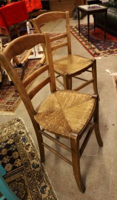 trois chaises en bois dans une pièce où il y a un tapis au sol