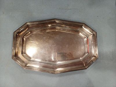 un plat en argent ancien posé sur une table, sur fond blanc