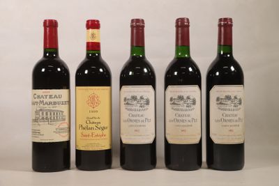 quatre bouteilles de vin rouge sont alignées sur une table