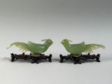 two green birds that are sitting on top of each other