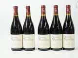 quatre bouteilles de vin sont alignées sur une surface blanche