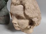 two clay heads of a woman and a statue of a man