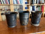 trois tasses posées sur une table devant une bibliothèque