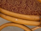 a close up of a wooden chair with a red patterned seat