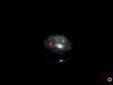 a black ball with a red light in the dark
