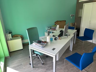 a white desk with blue chairs and a laptop on it