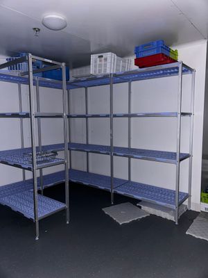 a room that has a shelf with shelves and bins on it