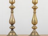 pair of antique brass candlesticks on a wooden table