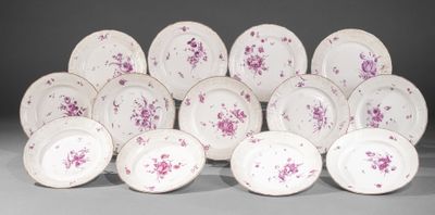 Plusieurs assiettes blanches et roses ornées de fleurs violettes sont empilées les unes sur les autres