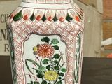 two vases sitting on a table with a brick wall in the background