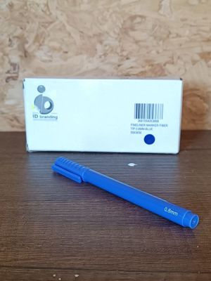 a blue pen sitting on a table next to a box