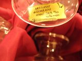 a wine glass with a label on it sitting on a red cloth
