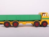 a green and yellow toy truck on a white surface