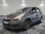 La petite voiture grise est garée dans le garage, sur le sol à carreaux.