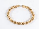 un bracelet en or tressé sur fond blanc