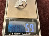 une balance en argent sur laquelle repose une bague en diamant