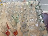 bottles and glasses on a table with a window in the background