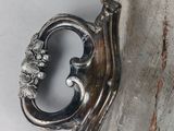 a silver vase that has a handle on it