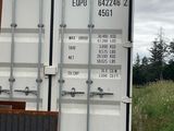a large white container sitting in the middle of a field