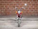 a red motorcycle parked in front of a brick wall