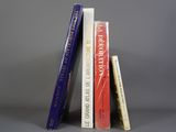trois livres sont empilés sur une surface grise