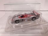a toy car in a clear display case on a white surface