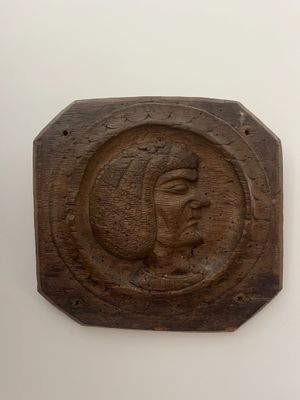 a wooden plaque with a picture of a woman on it