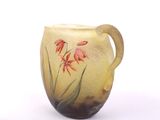 a yellow vase with red flowers on it on a white surface