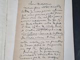 an old handwritten letter on a piece of paper on a table