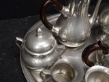 a silver tray with silver tea pots and silver cups on it