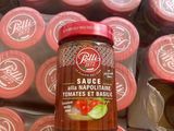 a jar of sauce sitting on top of a pile of cups