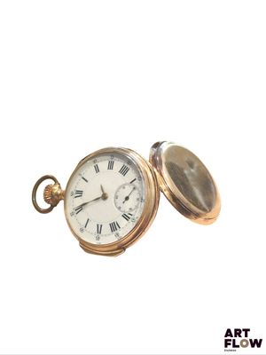 a gold pocket watch with roman numerals on it