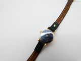 une image d'un gros plan d'une montre-bracelet sur une surface blanche