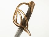 a close up of a sword with a gold handle on a white background