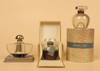 a bottle of perfume and a glass cup in a box