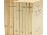 cinq livres empilés les uns sur les autres sur une surface blanche
