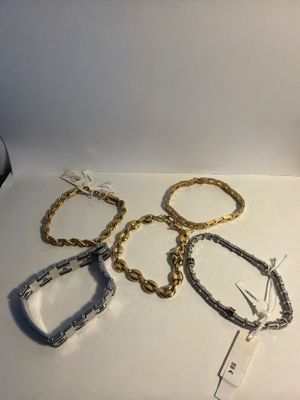 several bracelets and a bottle of wine sit on a table
