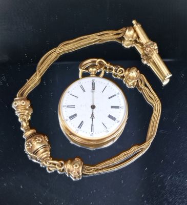 une montre de poche dorée, attachée à une chaîne