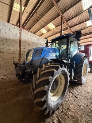 a blue tractor parked inside of a building next to a brick wall